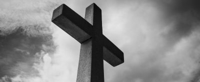 low angle photo of concrete cross under clouds