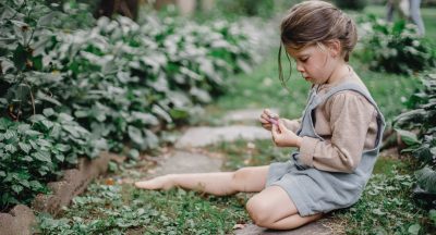 cute stylish child playing with chalks in the garden t