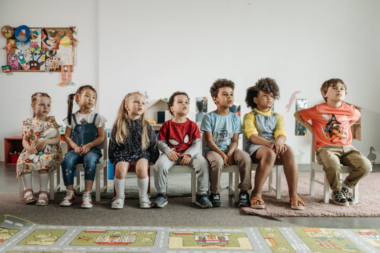 children sitting on stools in kindergarten