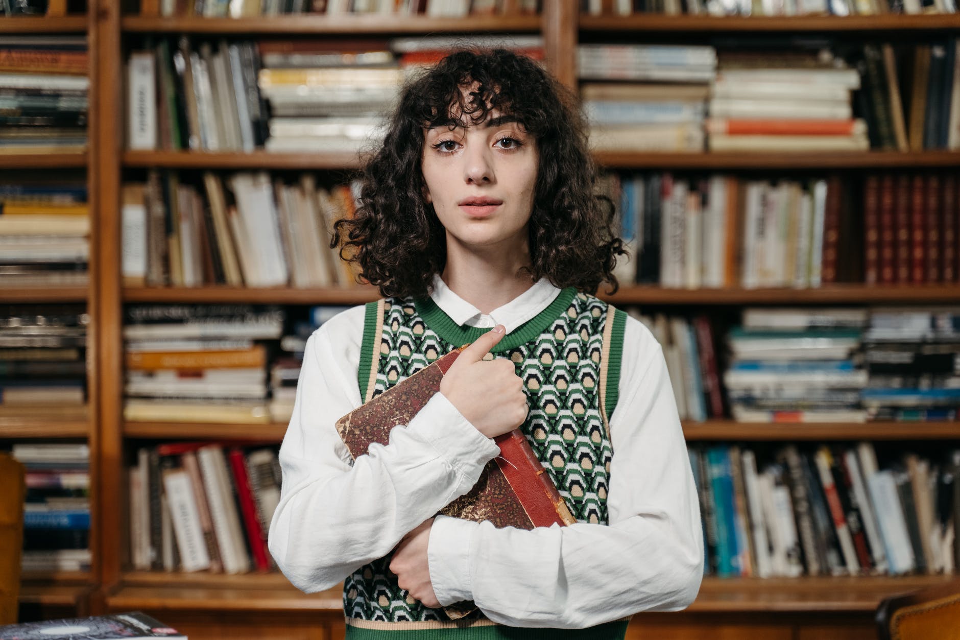 a woman holding a book in a library